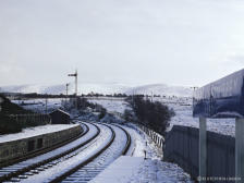 Home and starter signals at Grantown on Spey East are seen looking towards the north on 2 Nov 1968.  A new road alignment all but obliterates this cutting